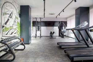a gym with treadmills and elliptical machines at Kazzhol Park Hotel Almaty in Almaty