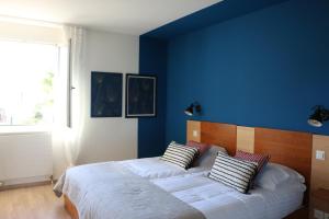 1 dormitorio con paredes azules y 1 cama con almohadas en Auberge Au Lion d'Or, en Tannay