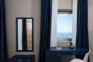 Hotel Belvedere في توري ديل أورسو: وجود مرآة على مكتب بجوار النافذة