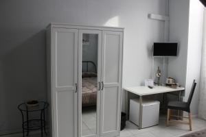 a white cabinet with a mirror in a bedroom at Affittacamere Roma in Sanremo