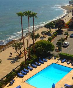 a beach filled with lots of beach chairs and umbrellas at Crowne Plaza Hotel Ventura Beach, an IHG Hotel in Ventura