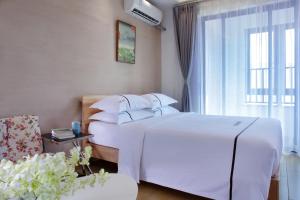 海口的住宿－克拉尔绿邸酒店(免费24小时美兰机场/动车接送)，卧室设有一张白色大床和一扇窗户。