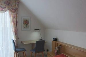 um quarto com uma secretária, 2 cadeiras e uma janela em Ferienhaus Mey em Bad Salzungen