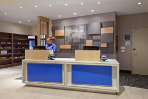 a woman sitting at a counter in a store at Holiday Inn Express Hotel & Suites Ventura Harbor, an IHG Hotel in Ventura