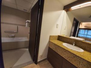 a bathroom with a sink and a tub and a mirror at Crown Regency Serviced Suites in Kuala Lumpur