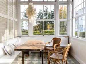 ein Esszimmer mit Tisch und Stühlen und Fenstern in der Unterkunft Villa Erika in Göhren