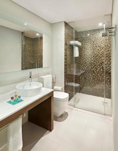 a bathroom with a toilet sink and a shower at Hyatt Place Dubai Al Rigga Residences in Dubai