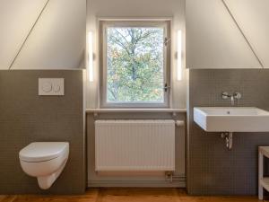 ein Badezimmer mit Toilette und Waschbecken und einem Fenster in der Unterkunft Villa Erika in Göhren