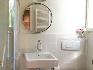 ein weißes Badezimmer mit Waschbecken und Spiegel in der Unterkunft Villa Erika in Göhren + 23 Fotos