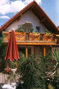 a house with a balcony and an umbrella at Ferienhaus Mey in Bad Salzungen