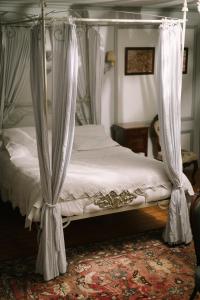 a bedroom with a canopy bed with curtains at Domaine de Rennebourg in Saint Denis Du Pin