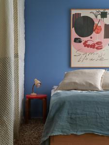 Dormitorio azul con cama y mesa roja en Noli Sörnäinen, en Helsinki