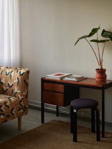 a desk with a potted plant and a chair at Noli Sörnäinen in Helsinki