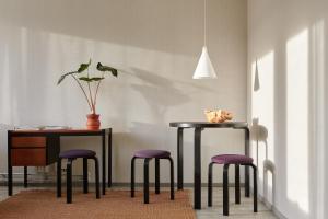 a dining room with a table and three stools at Noli Sörnäinen in Helsinki