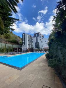 uma grande piscina em frente a um edifício em Santa Cruz Village Hotel em Santa Cruz - Madeira