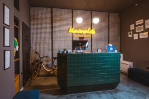 a restaurant with a green counter with a neon sign at Hotel Marienplatz Podgorica in Podgorica
