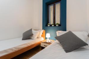 a bedroom with two beds and a window with plants at Family Lake Apartment by Rent All Como in Mezzegra