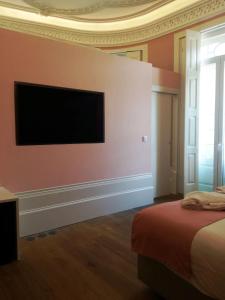 a bedroom with a bed and a television at EMAJ Boutique Hotel in Guimarães