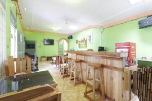 een bar in een restaurant met groene muren bij Waroeng Transit & Depary Homestay in Binjai