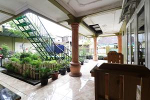 un vestíbulo con una escalera y macetas en Waroeng Transit & Depary Homestay, en Binjai