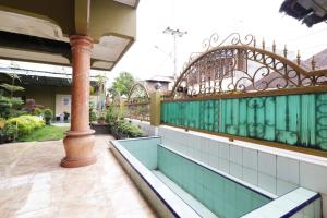 een balkon van een gebouw met een groen hek bij Waroeng Transit & Depary Homestay in Binjai