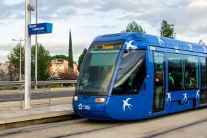 a blue bus is driving down a street at Hôtel Lapeyronie in Montpellier +7 photos