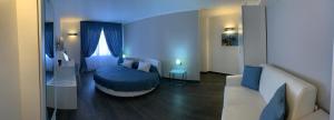 a bedroom with a blue bed and a couch at B&B Al Picchio in Monopoli