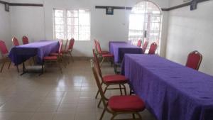 a dining room with blue tables and red chairs at Rest Gardens Ltd in Kampala
