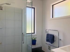 a bathroom with a glass shower and a sink at The Garden Studio - Queenstown in Queenstown