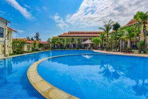 a large blue swimming pool in front of a building at MANLI Resort Quảng Bình in Dong Hoi