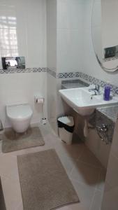 a bathroom with a sink and a toilet and a mirror at Mirage 1 Residence Modern 1 Bedroom Apartment with balcony Dubai Silicon Oasis in Dubai