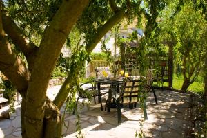 a table and chairs under a tree in a yard at Gatekeeper's Retreat in Niagara on the Lake