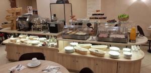 ein Buffet mit Tellern und Speisen zur Präsentation in der Unterkunft Hotel Champerret Elysees in Paris