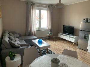 a living room with a couch and a tv at Apartament „Ogrodowa” in Bolesławiec