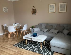 sala de estar con sofá y mesa en Apartament „Ogrodowa”, en Bolesławiec