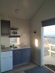 a kitchen with a sink and a microwave at Ofanleiti Cottages in Vestmannaeyjar