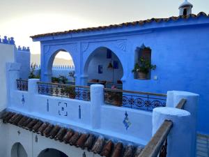 a building painted blue and white with a balcony at Casa Perleta in Chefchaouene