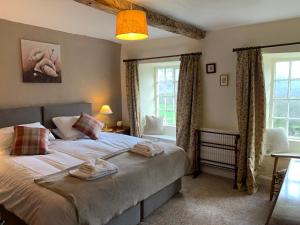 a bedroom with a bed with towels on it at Witherslack Hall Farmhouse in Grange Over Sands