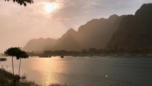 a group of boats on a river with mountains at Applebee's Homestay in Phong Nha