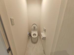 a bathroom with a toilet in a white room at Private House Naturwald in Furano