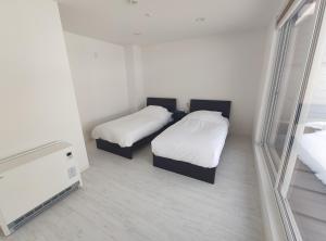 2 Betten in einem kleinen Zimmer mit Spiegel in der Unterkunft Private House Naturwald in Furano