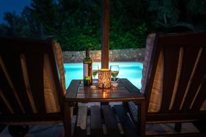 a table with a bottle of wine and two glasses at Villa Amit in Sivota
