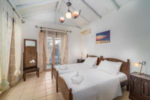 a bedroom with two beds and a window at Villa Amit in Sivota +39 photos