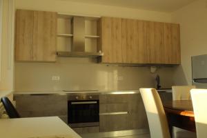- une cuisine avec des placards en bois, une table et une cuisinière dans l'établissement Costantino home, à Macerata