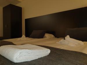 a bedroom with two beds with white sheets at Ariston Hotell in Lidingö