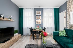 a living room with a green couch and a table at Deluxe Old Town Apartment by Renters in Poznań