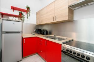 a kitchen with red cabinets and a sink at Deluxe Old Town Apartment by Renters in Poznań