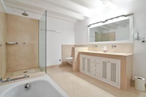 ein Badezimmer mit einer Badewanne, einem Waschbecken und einem Spiegel in der Unterkunft Palacio Can Marqués in Palma de Mallorca