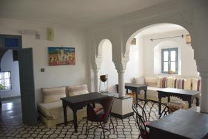 a living room with a couch and a table and chairs at Casa Perleta in Chefchaouene