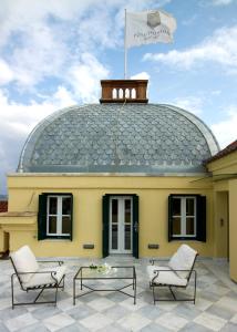 a yellow building with a flag on top of it at Poseidonion Grand Hotel in Spetses